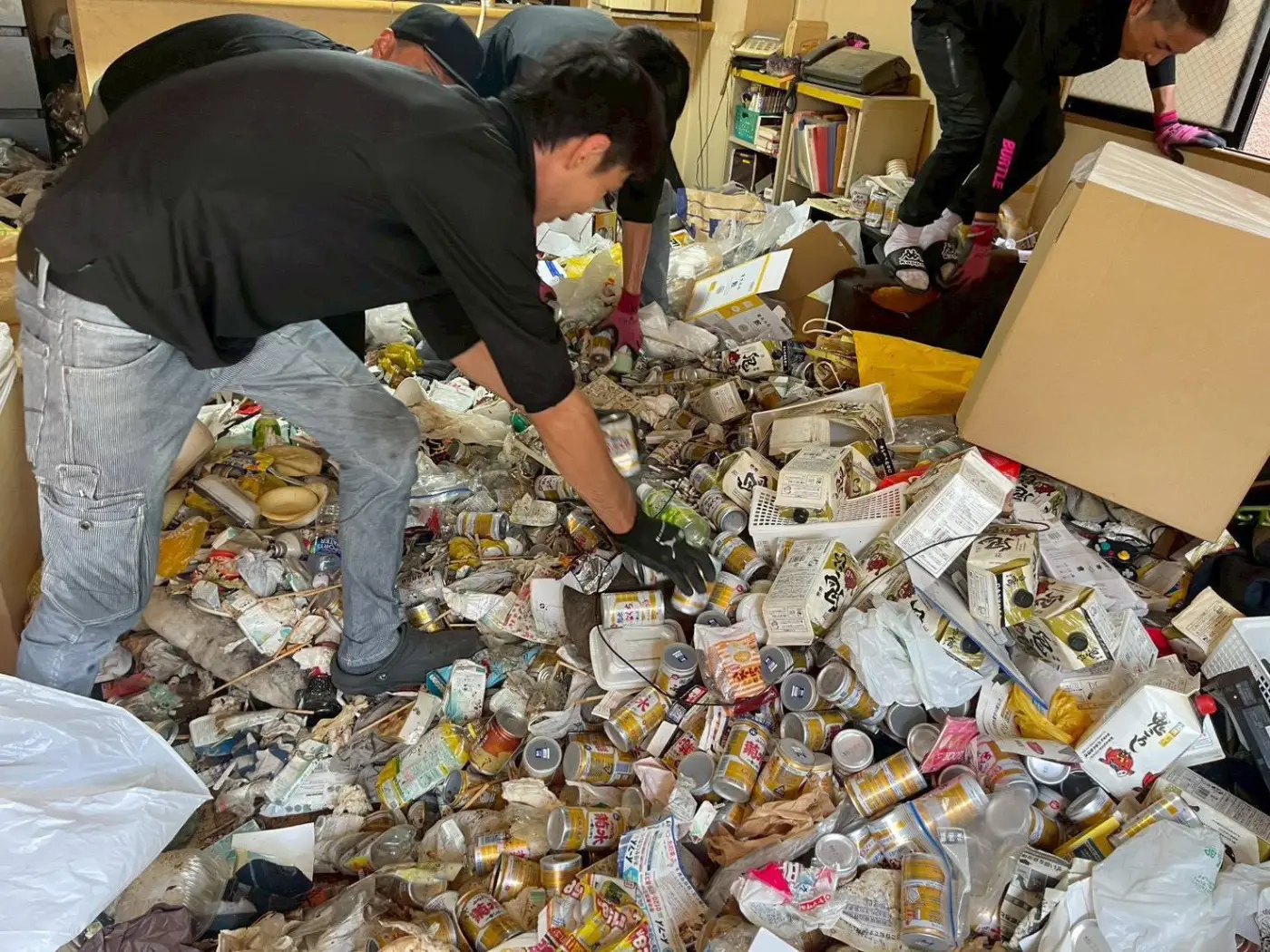 ゴミ屋敷で仕分け作業を行うスタッフ
