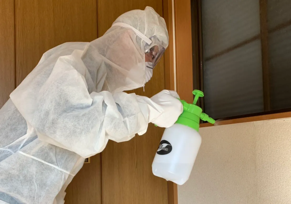 防護服を着て消臭・除菌作業を行う特殊清掃スタッフ